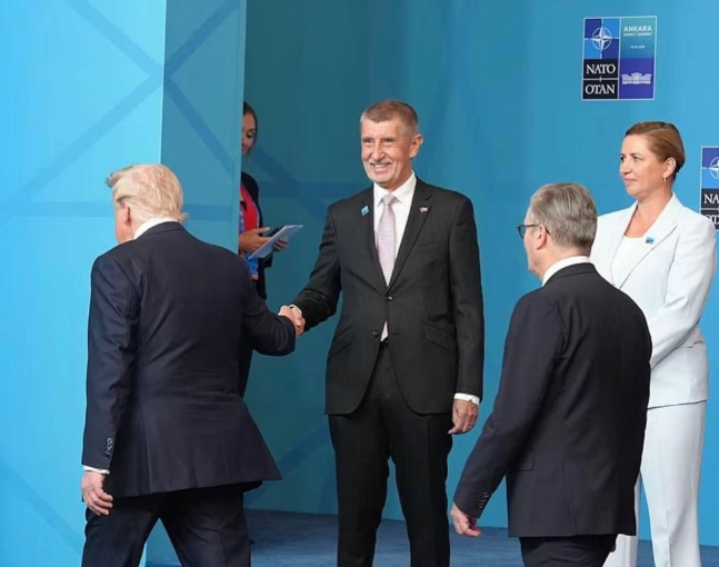 Náhledový obrázek k článku, který se zaobírá tématem podání ruky mezi Donaldem Trumpem a Andrejem Babišem na Summitu NATO 2026, který ukazuje záměrně účelovou fotomontáž.
